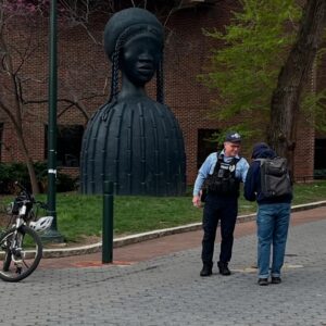 photo of a police officer talking with a pedestrian on campus