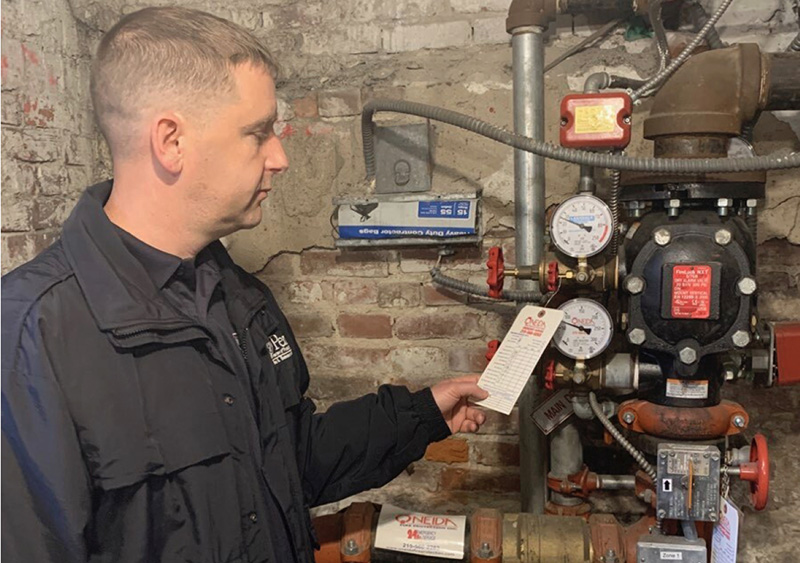 Member of Fire & Emergency Services checking fire safety equipment