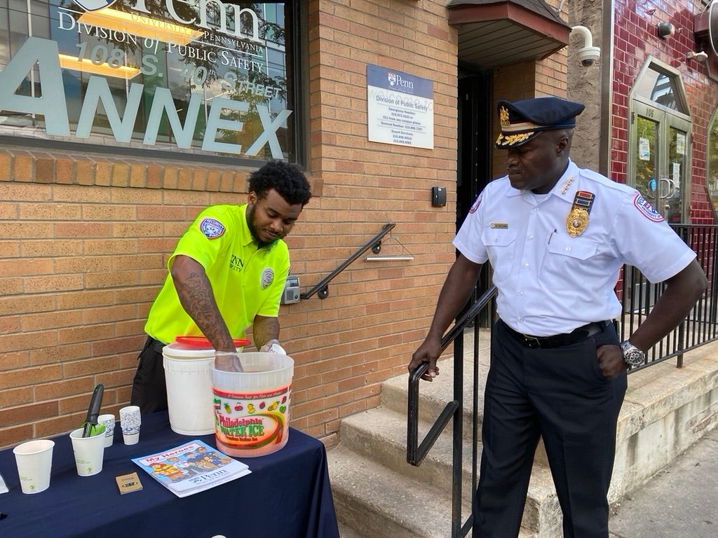 An Allied Security Officer scoops water ice while talking with chief Gary Williams