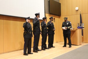 New officers with their right hands raised, are sworn in for duty