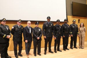 Officers in formal uniform line up to be sworn in for duty in their new roles