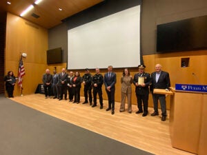 Administrators and personnel from DPS, Penn Medicine, and PPD pose at the front of the auditorium