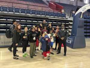 a group of PAL children pose in teh Palestra, a large historic basketball facility