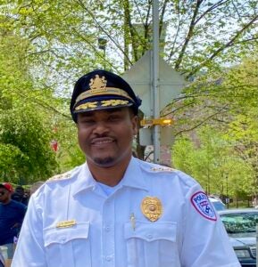 Photo of Chief Wood in a white shirt and black police hat. 