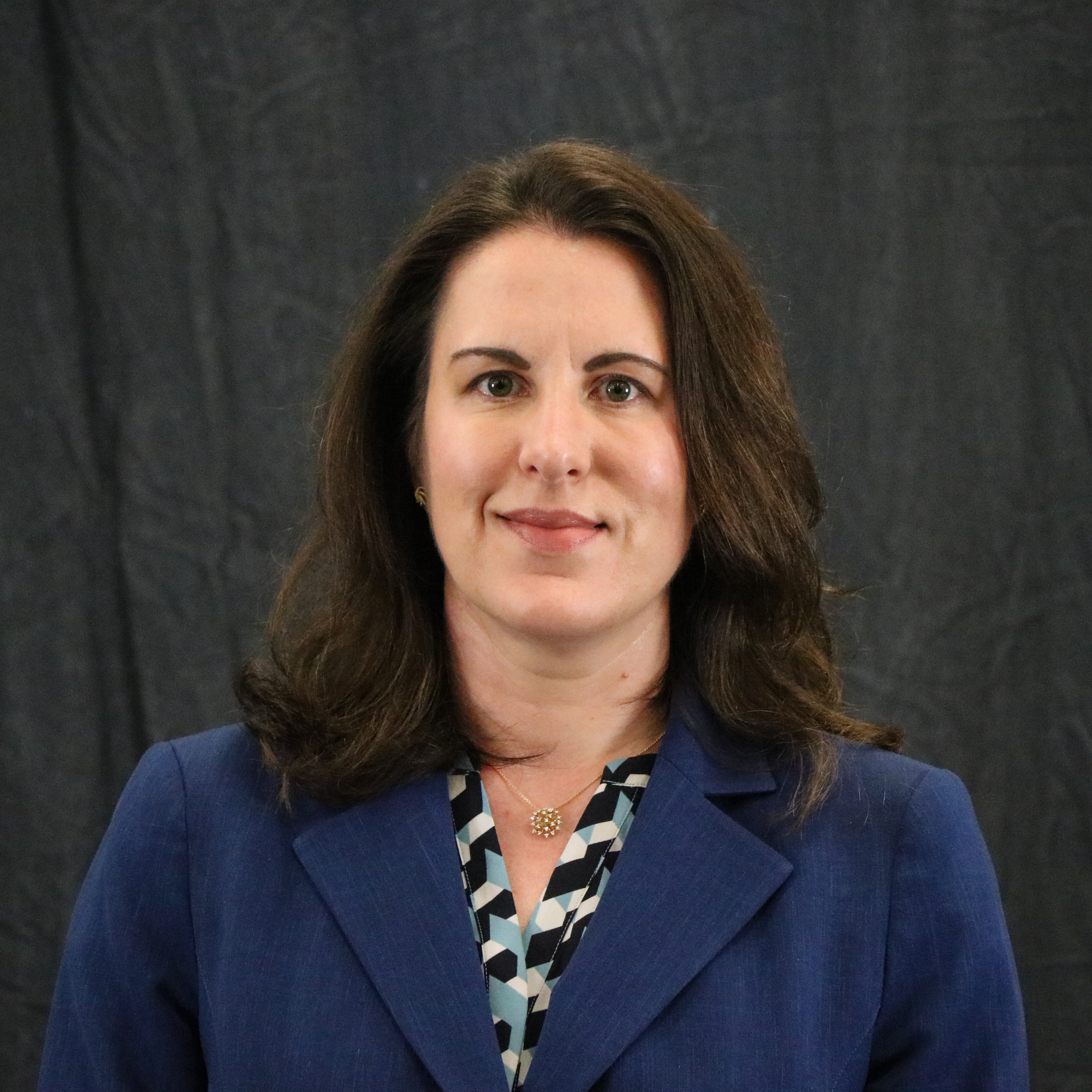 Photo of a woman with blond hair wearing a black suit jacket